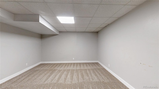 carpeted empty room with a drop ceiling