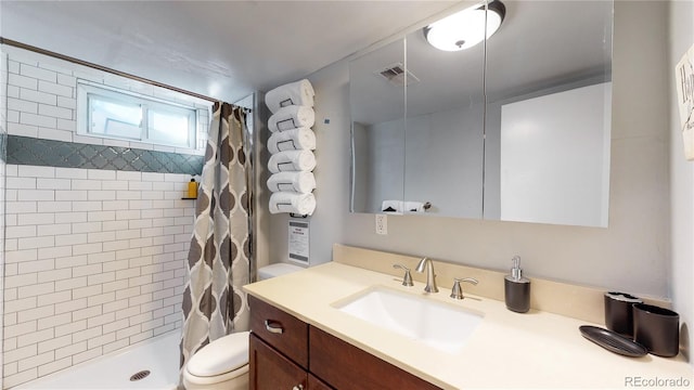 bathroom featuring curtained shower, vanity, and toilet