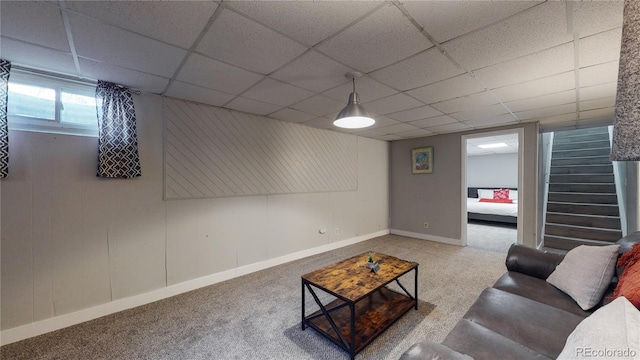 living room featuring carpet flooring and a paneled ceiling