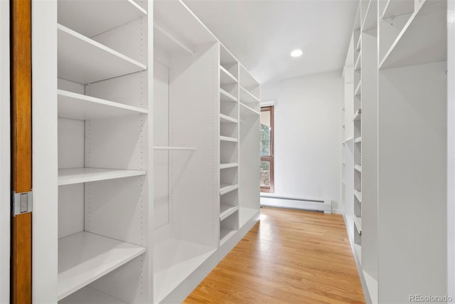 walk in closet featuring a baseboard radiator and wood finished floors