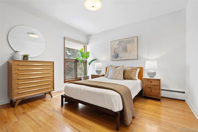 bedroom featuring a baseboard radiator, wood finished floors, and baseboards