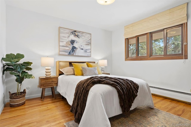 bedroom featuring baseboards, baseboard heating, and wood finished floors