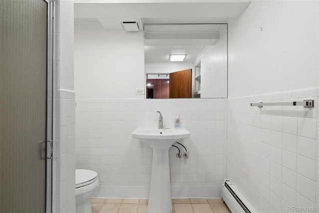 bathroom featuring visible vents, toilet, a wainscoted wall, tile patterned floors, and tile walls