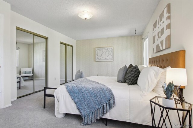 1791 S Laredo St, Aurora, CO 80017 - bedroom with wallpapered walls, multiple closets, carpet, and a textured ceiling