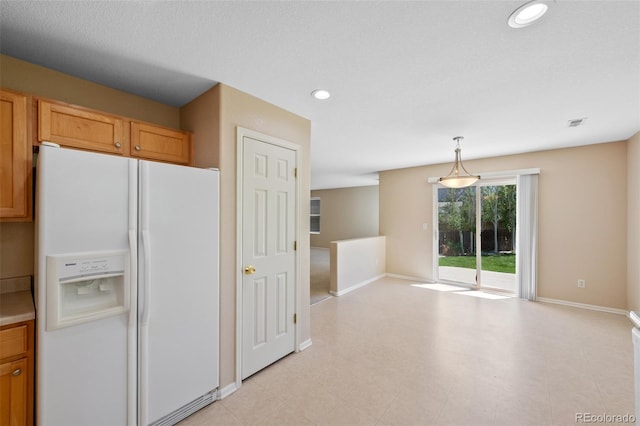 16256 E Otero Pl, Englewood, CO 80112 - kitchen with white refrigerator with ice dispenser, open floor plan, baseboards, recessed lighting, and hanging light fixtures
