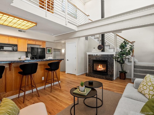 225 N Lincoln St Unit 4, Denver, CO 80203 - living area featuring stairs, light wood-type flooring, and a towering ceiling