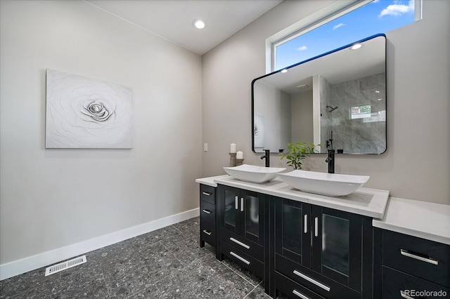 5838 S Louthan St, Littleton, CO 80120 - bathroom featuring double vanity, a tile shower, and recessed lighting