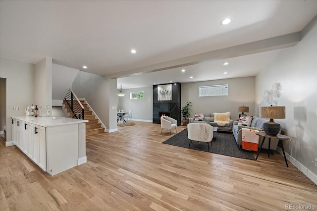 5838 S Louthan St, Littleton, CO 80120 - living room featuring stairs, light wood-style flooring, recessed lighting, and a tile fireplace