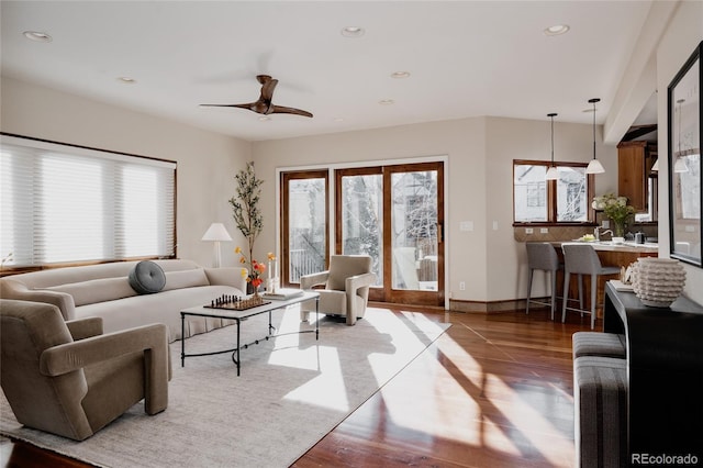 living room featuring recessed lighting, a ceiling fan, baseboards, and wood finished floors