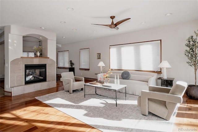 living room with recessed lighting, wood finished floors, a ceiling fan, and a tile fireplace