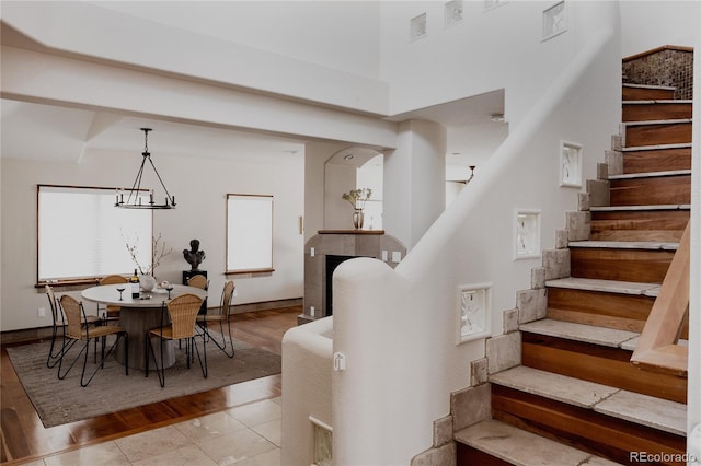 dining room featuring stairway, wood finished floors, visible vents, baseboards, and a chandelier