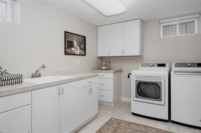 clothes washing area featuring light tile patterned floors, cabinet space, independent washer and dryer, and a sink