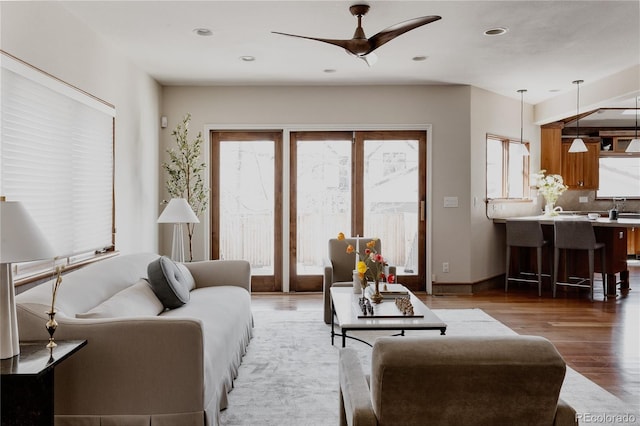 living area featuring recessed lighting, baseboards, wood finished floors, and a ceiling fan