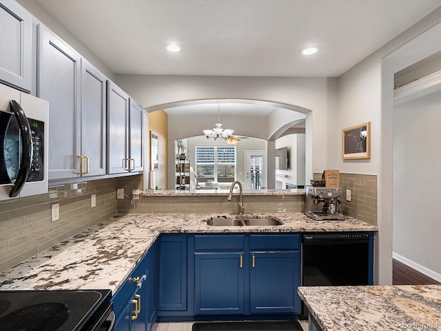 1747 N Pearl St Unit 306, Denver, CO 80203 - kitchen featuring a sink, stainless steel microwave, a chandelier, blue cabinetry, and decorative backsplash