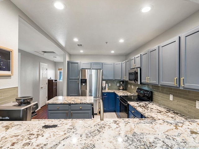 1747 N Pearl St Unit 306, Denver, CO 80203 - kitchen with appliances with stainless steel finishes, light stone countertops, backsplash, wood finished floors, and recessed lighting