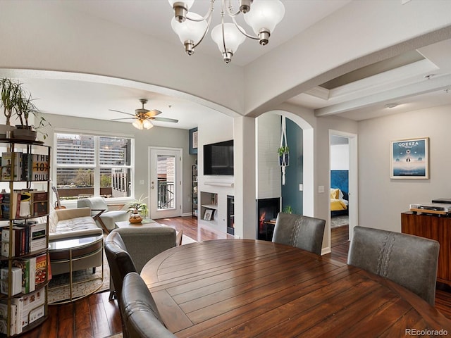 1747 N Pearl St Unit 306, Denver, CO 80203 - dining area with hardwood / wood-style floors, arched walkways, a warm lit fireplace, ceiling fan, and a chandelier