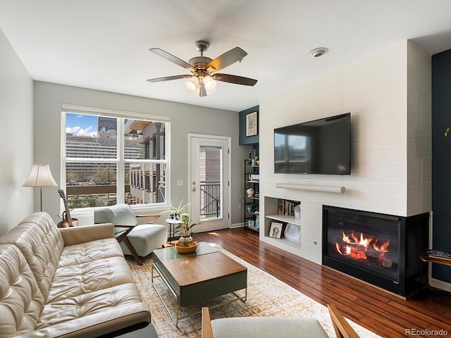 1747 N Pearl St Unit 306, Denver, CO 80203 - living room featuring wood finished floors, ceiling fan, a large fireplace, and baseboards