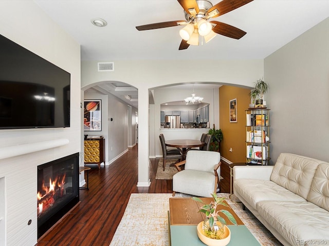 1747 N Pearl St Unit 306, Denver, CO 80203 - living area featuring arched walkways, wood finished floors, a ceiling fan, a glass covered fireplace, and baseboards