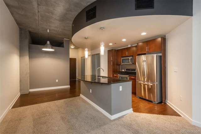 kitchen featuring pendant lighting, sink, dark colored carpet, and appliances with stainless steel finishes