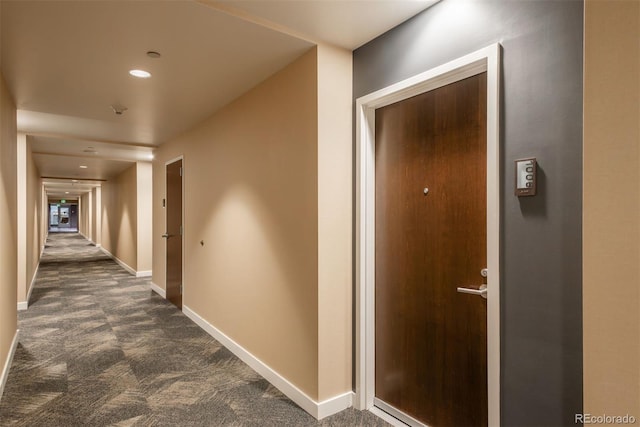 hallway with dark colored carpet