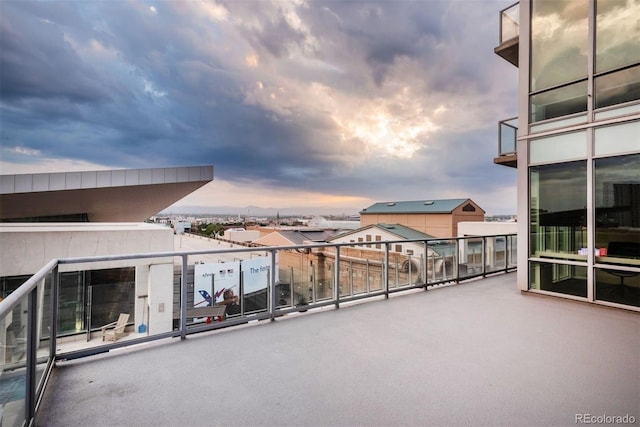 patio terrace at dusk featuring a balcony