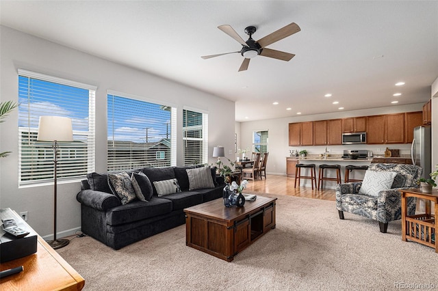 living room featuring ceiling fan and light hardwood / wood-style floors