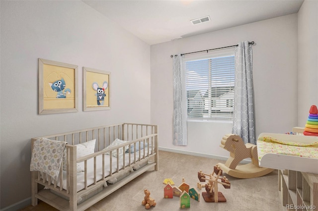 carpeted bedroom featuring a nursery area