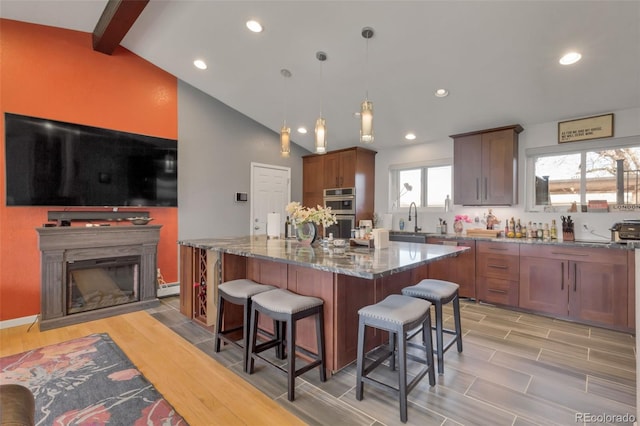 kitchen featuring decorative light fixtures, a center island, a healthy amount of sunlight, and light hardwood / wood-style flooring