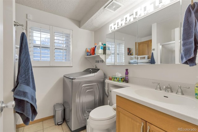 bathroom featuring washer / dryer, tile patterned flooring, a textured ceiling, toilet, and vanity