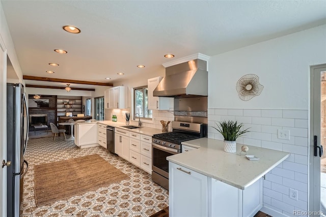 6487 W Weaver Ave, Littleton, CO 80123 - kitchen featuring stainless steel appliances, wall chimney range hood, a sink, a peninsula, and white cabinets