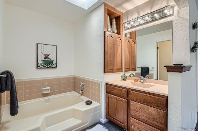 6487 W Weaver Ave, Littleton, CO 80123 - full bathroom featuring a bath, vanity, a skylight, and a textured wall