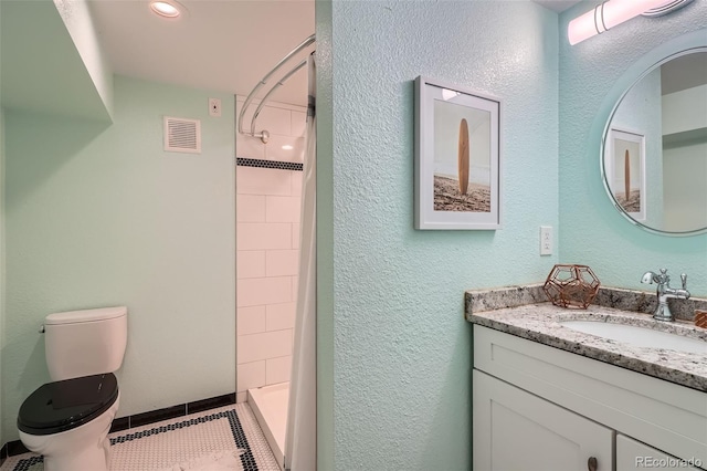 6487 W Weaver Ave, Littleton, CO 80123 - bathroom featuring tiled shower, toilet, vanity, and tile patterned floors