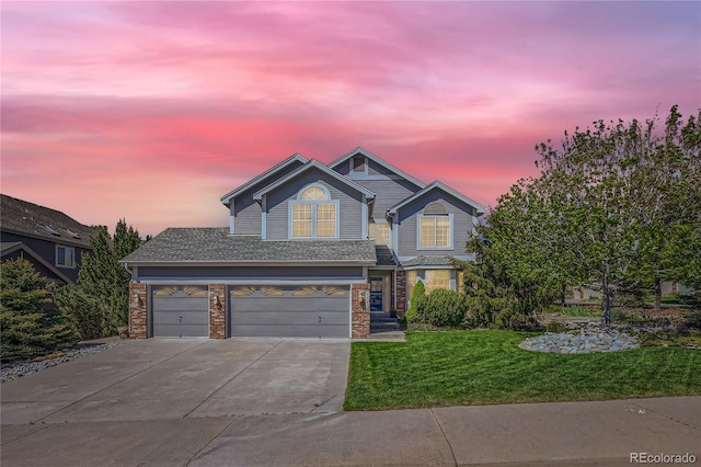 view of front of house with concrete driveway, a lawn, and an attached garage