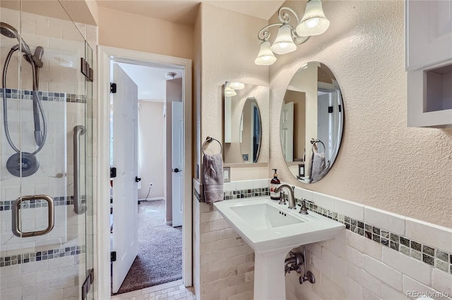 full bathroom with wainscoting, a shower stall, and tile walls