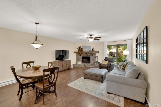 620 Macgregor Ave Unit 11, Estes Park, CO 80517 - living room with wood finished floors, a ceiling fan, a fireplace, and a textured ceiling