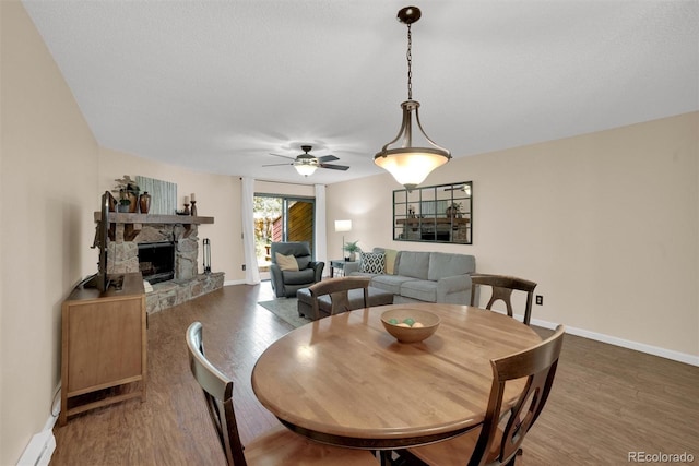 620 Macgregor Ave Unit 11, Estes Park, CO 80517 - dining area featuring wood finished floors, a fireplace, and ceiling fan