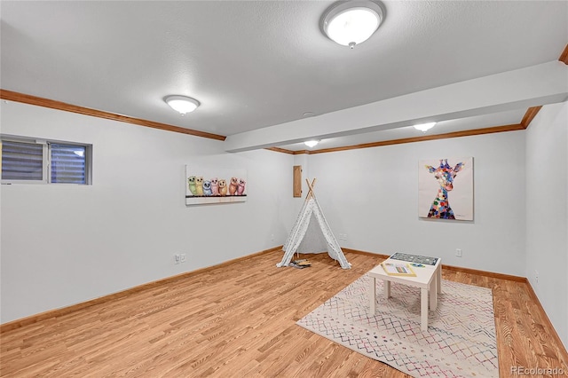 rec room with hardwood / wood-style floors, crown molding, and a textured ceiling