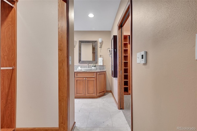 hallway featuring sink and light tile patterned floors