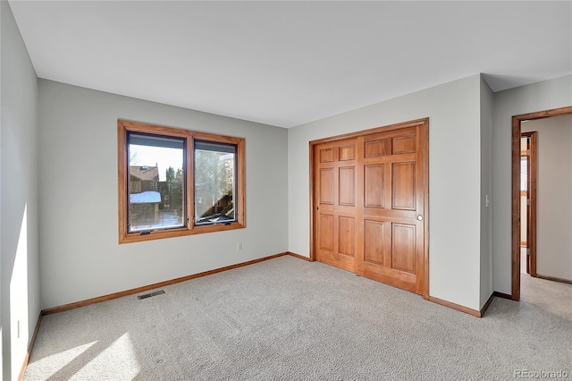 unfurnished bedroom featuring a closet and light carpet