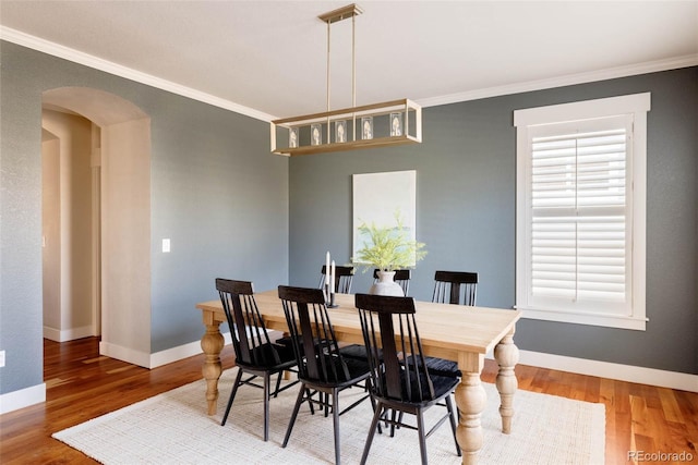 dining space featuring crown molding and wood-type flooring