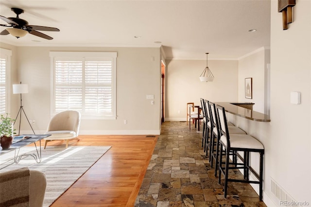 sitting room featuring dark wood-type flooring, ceiling fan, and ornamental molding