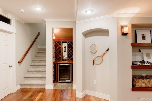 interior space featuring ornamental molding, wine cooler, and wood-type flooring