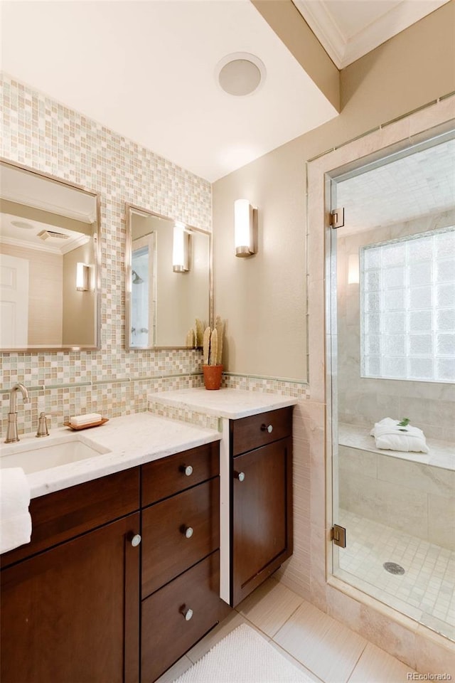 bathroom featuring crown molding, vanity, tile patterned floors, a shower with shower door, and tasteful backsplash