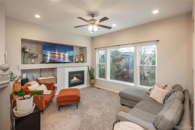 living room with baseboards, a tiled fireplace, ceiling fan, carpet flooring, and recessed lighting