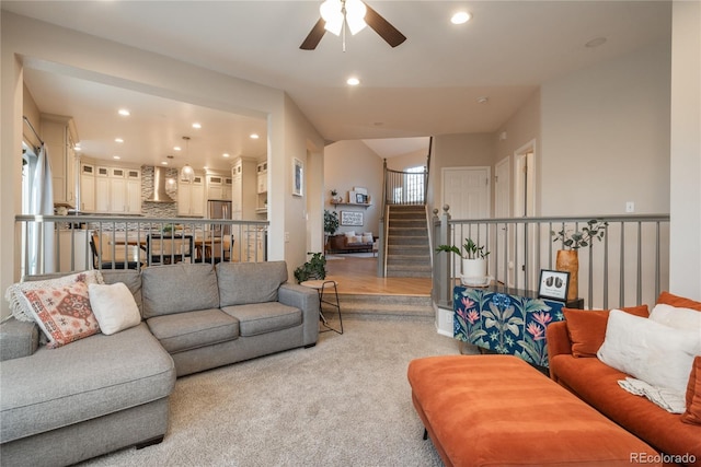 living room with light carpet, ceiling fan, stairway, and recessed lighting