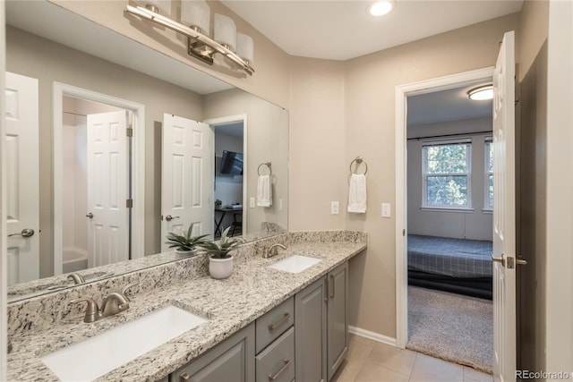 bathroom with double vanity, tile patterned flooring, a sink, and baseboards