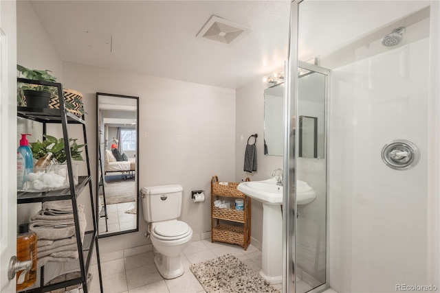 full bathroom with tile patterned flooring, baseboards, a shower stall, and toilet