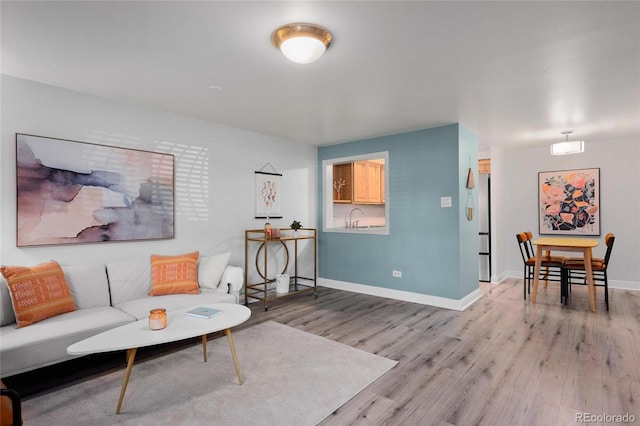 living room with sink and light hardwood / wood-style flooring