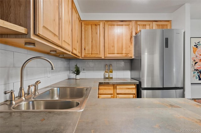 kitchen featuring sink, decorative backsplash, stainless steel fridge, and light brown cabinets