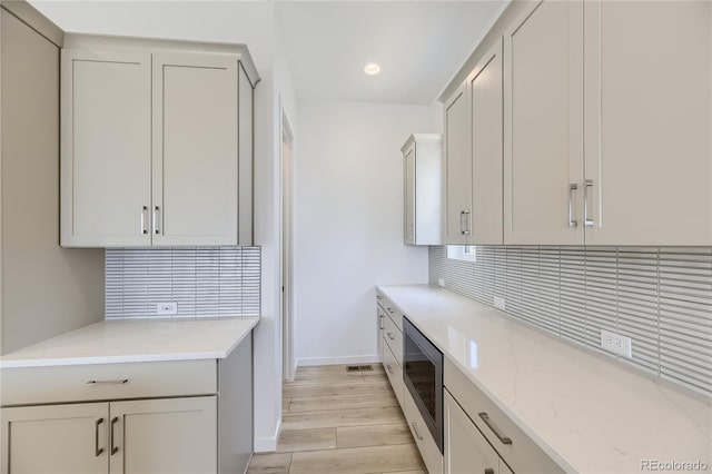 kitchen featuring light stone countertops and light wood-type flooring